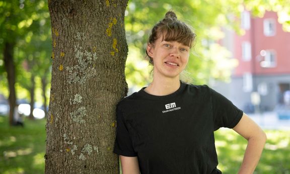 Caroline Schiöld på Einar Mattssons utemiljöavdlelning lutar sig mot ett träd
